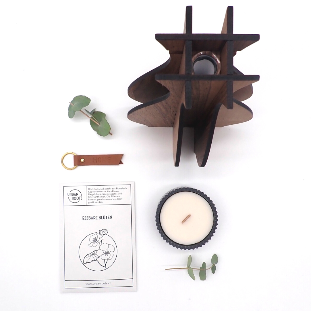 Les produits du coffret "Sunday at home" sont disposés à plat, en deux lignes verticales. Deux branches d'eucalyptus agrémente l'image de chaque côté des produits.