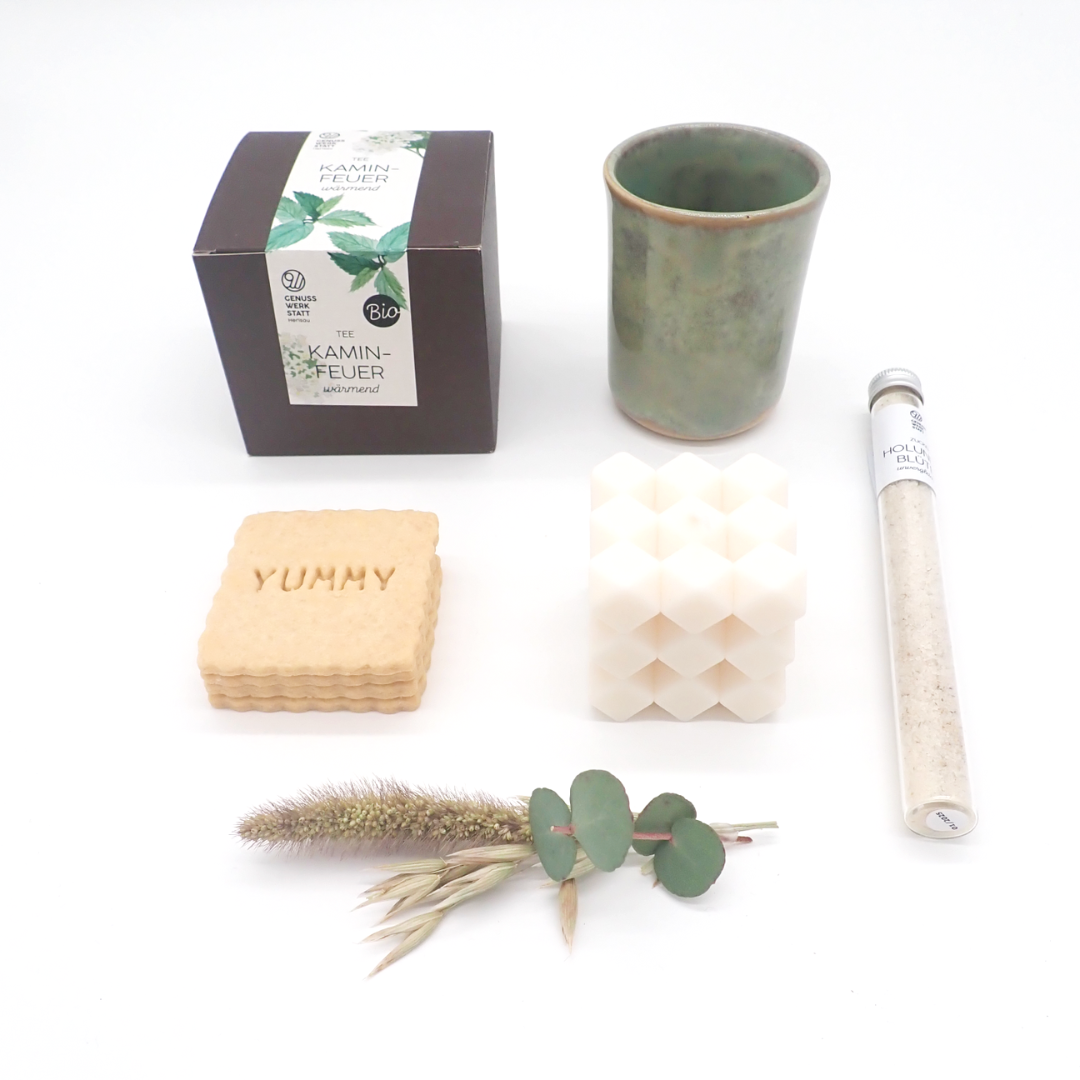 Les produits du coffret "Tea by afan'y" sont disposés à plat, en lignes verticales. Un petit bouquet de fleurs séchées est posé en bas de l'image.